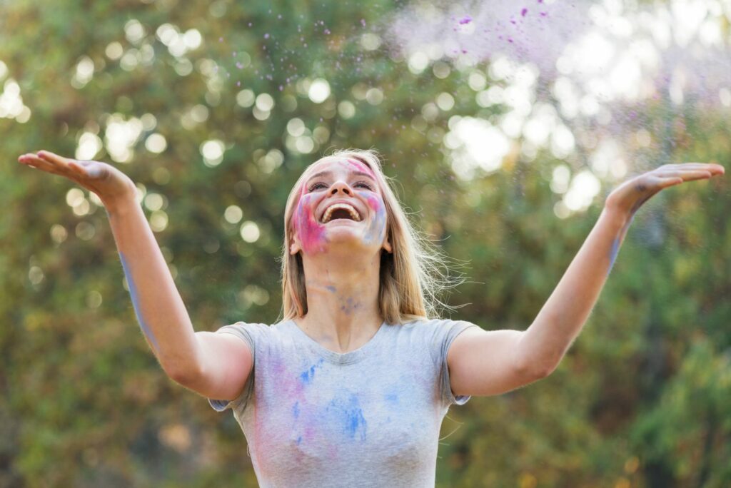 femme souriante les bras en l'air , heureuse, montrant ce que c'est de ressentir l'abondance dans la vie