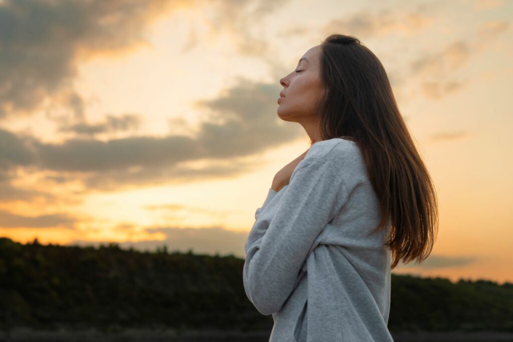 jeune femme se tenant les mains sur le coeur montrant que nos émotions non exprimées impactent notre corps