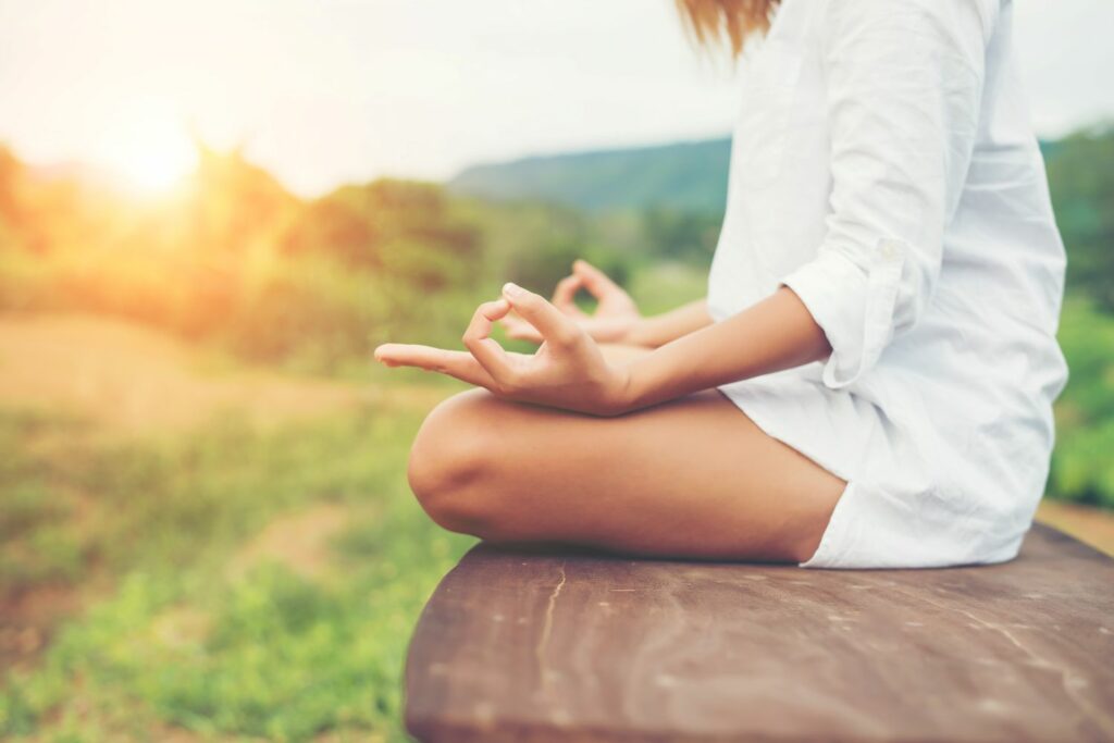 jeune femme assise doigt en mantra montrant le calme et l'efficacité des soins énergétiques