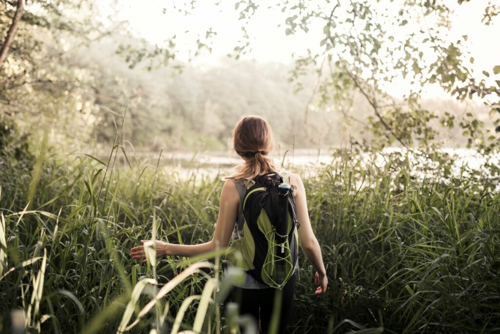 jeune femme de dos traversant la foret après avoir perdu ses repères