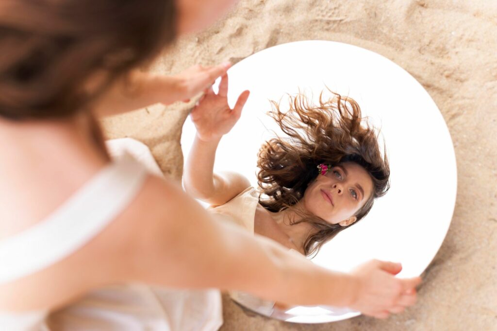jeune femme face a un miroir se regardant en se retrouvant elle même en ayant fait tomber ses masques