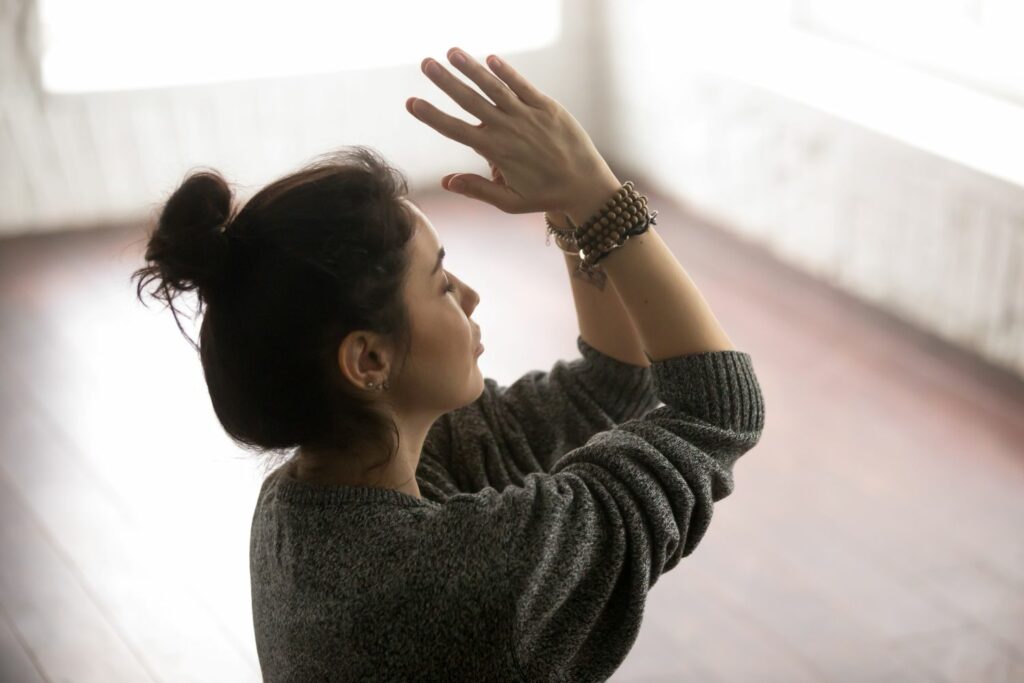 jeune femme remerciant en namasté synonyme de connaissance de soi éviter les guerres d'ego