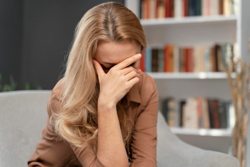 femme main sur le front montrant les signes d'épuisements émotionnels