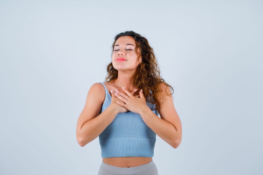 jeune femme mains sur la poitrine montrant Quels sont les 4 types de respiration